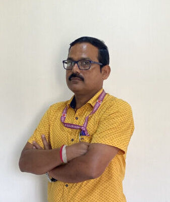 Man in yellow shirt standing indoors