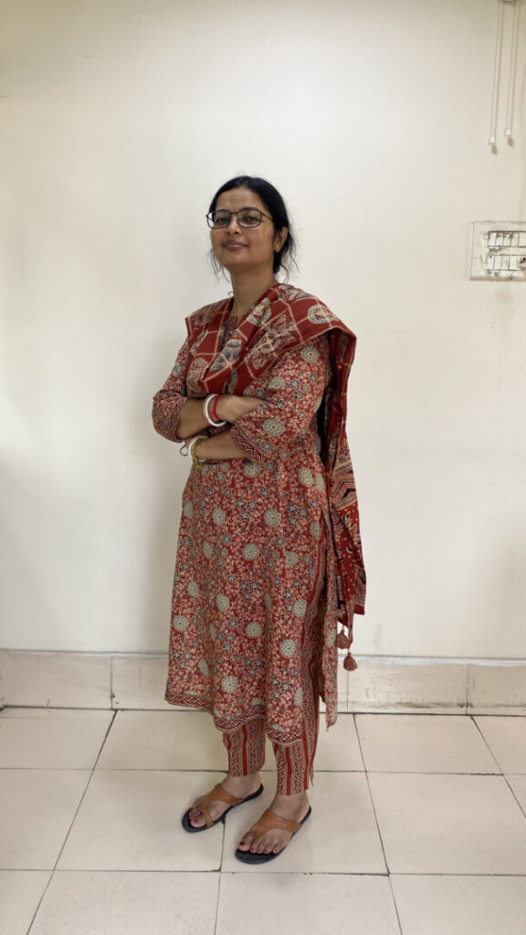 Woman in red traditional attire standing indoors