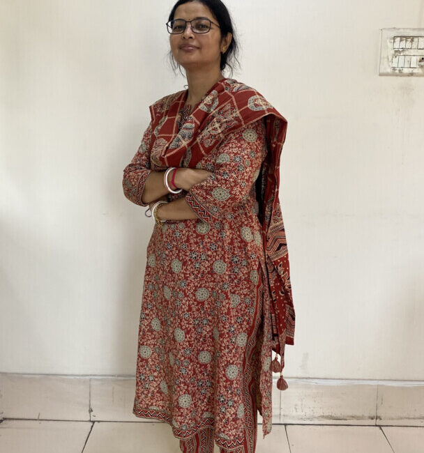 Woman in red traditional attire standing indoors