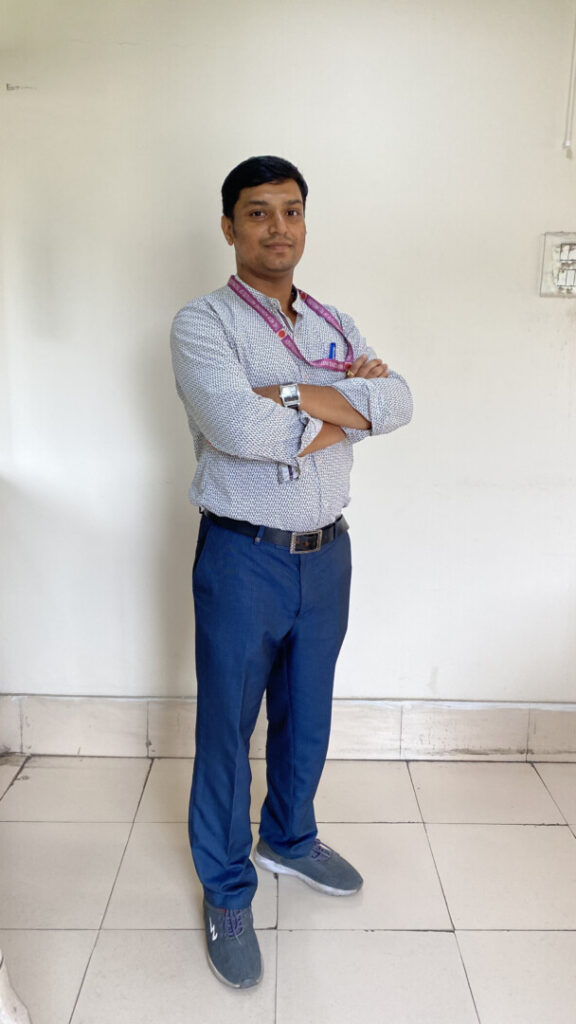 Person standing with arms crossed, blue pants.