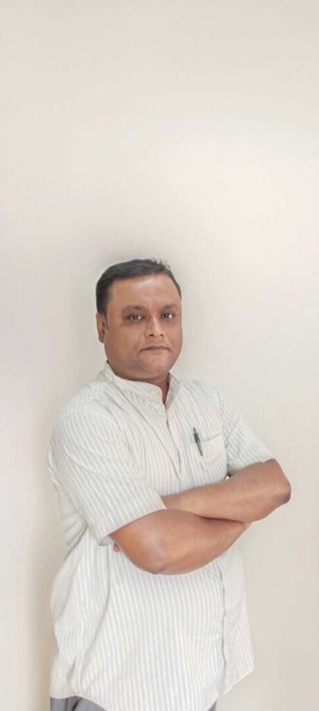 Man with crossed arms poses against a light wall