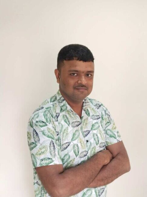 Man in leaf patterned shirt crossing arms