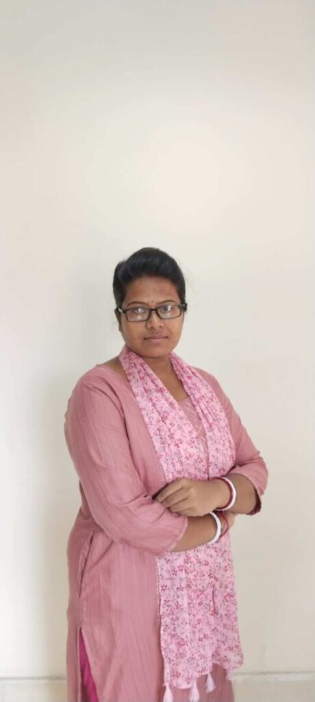 Woman in pink outfit with crossed arms.