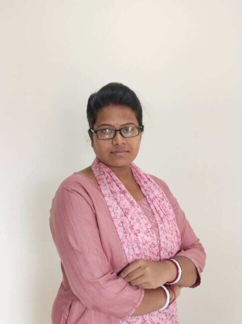 Woman in pink outfit with crossed arms.