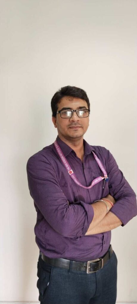 Man in purple shirt with lanyard.