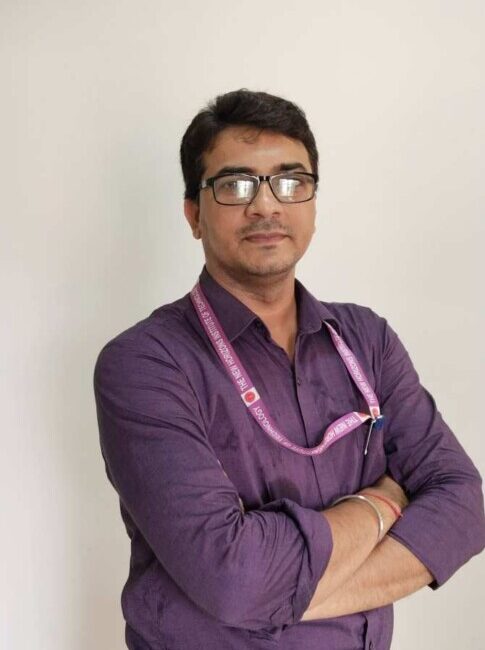 Man in purple shirt with lanyard.