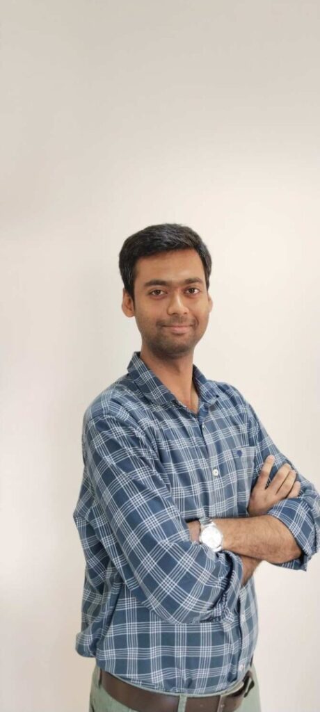 Man in blue plaid shirt with arms crossed.