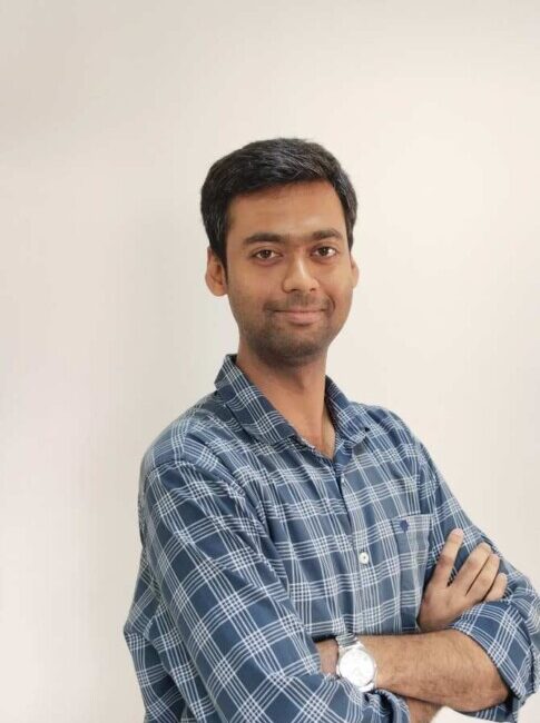 Man in blue plaid shirt with arms crossed.