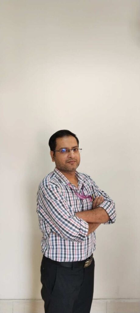 Man in checked shirt with arms crossed.