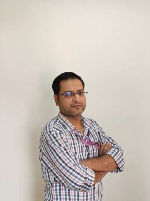 Man in checked shirt with arms crossed.