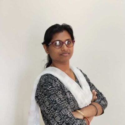 Woman with glasses crossing arms, wearing traditional attire