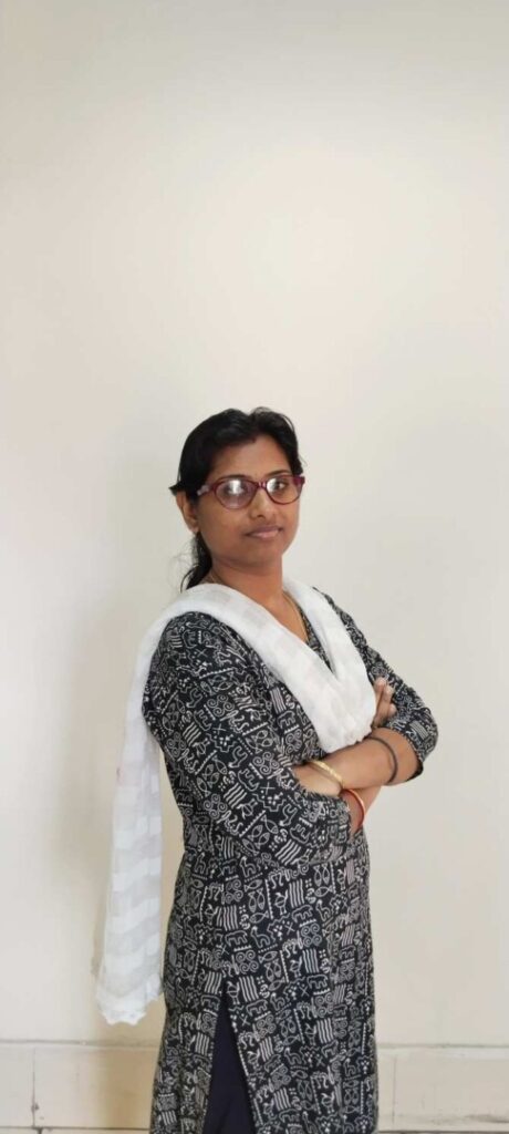 Woman with glasses crossing arms, wearing traditional attire