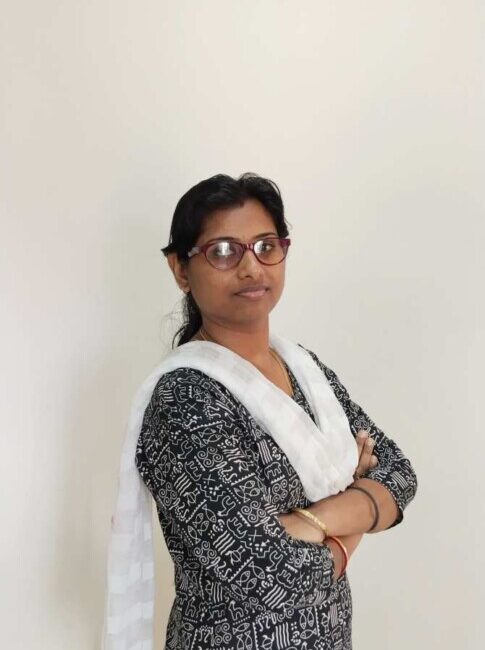 Woman with glasses crossing arms, wearing traditional attire