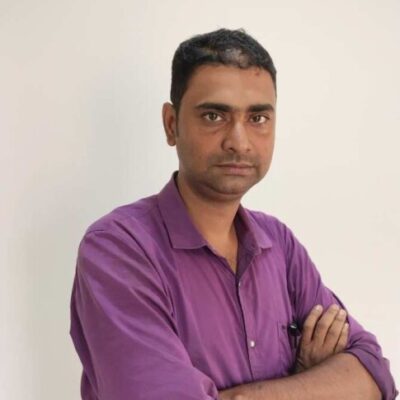 Man in purple shirt with arms crossed.