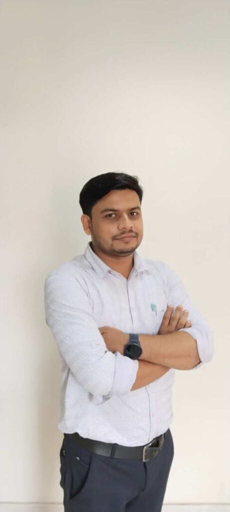 Man standing with arms crossed against white wall.