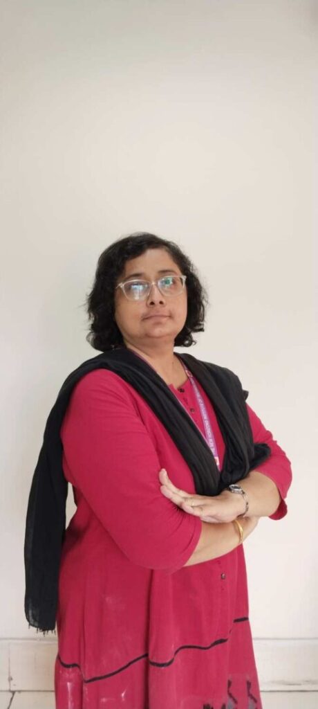 Woman in red kurta with black scarf.