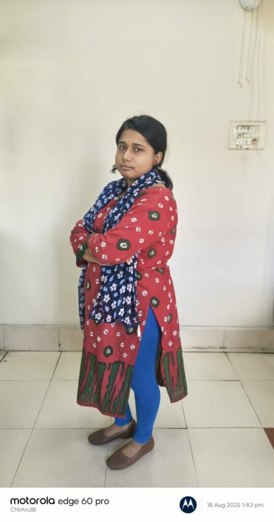 Person in colorful outfit with arms crossed.