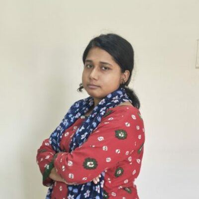 Person in colorful outfit with arms crossed.