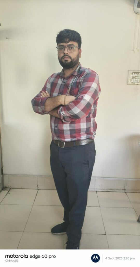 Person in plaid shirt standing indoors.