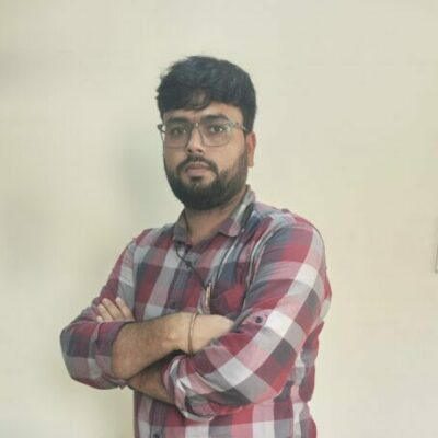 Person in plaid shirt standing indoors.