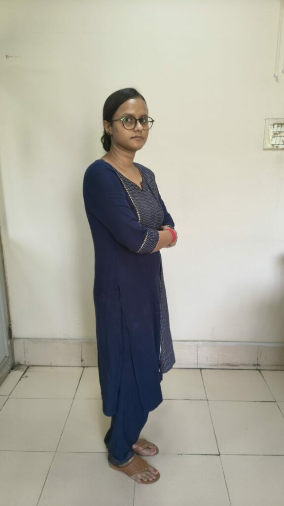 Person standing in blue traditional attire indoors.