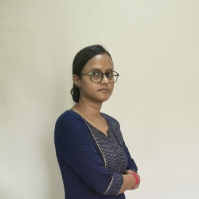Person standing in blue traditional attire indoors.