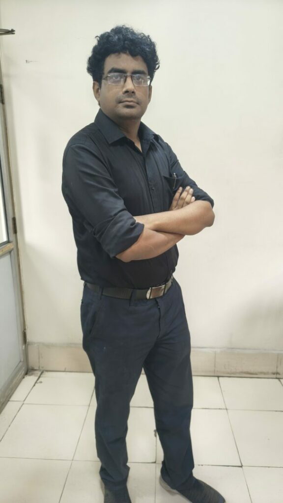 Person in black attire standing confidently indoors.