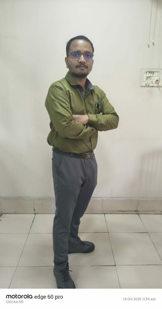 Man standing with arms crossed in office.