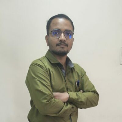 Man standing with arms crossed in office.